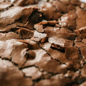 Detailed close-up of a cracked chocolate brownie surface, showcasing texture and rich flavor.